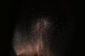 Gold sand explosion isolated on black background. Abstract sand cloud.