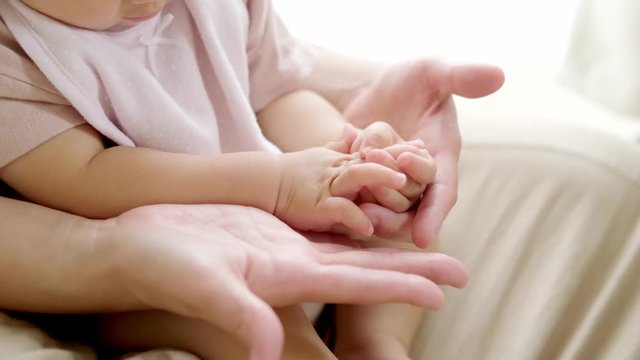 赤ちゃんの手を握るお母さん