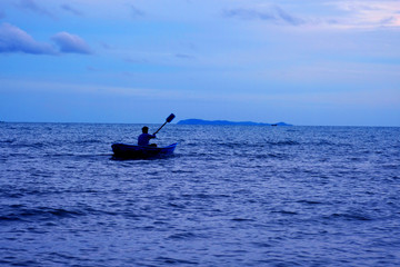 A man rolls boat on blue sea