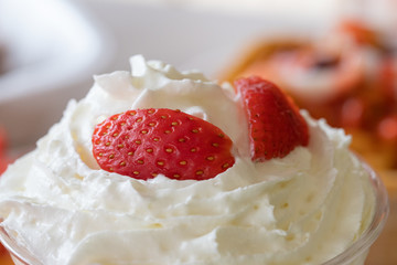 Closeup selective focus shot of whipped cream with fresh strawberries