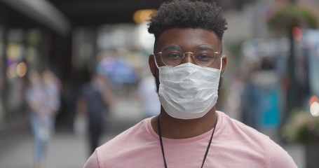 Young black man in city wearing a mask 