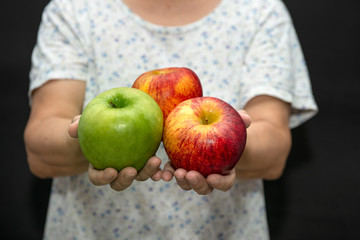Red and green apple in woman hands