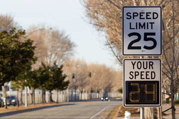 Fototapeta 25 mph speed limit sign and radar speed indicator sign on a street. obraz