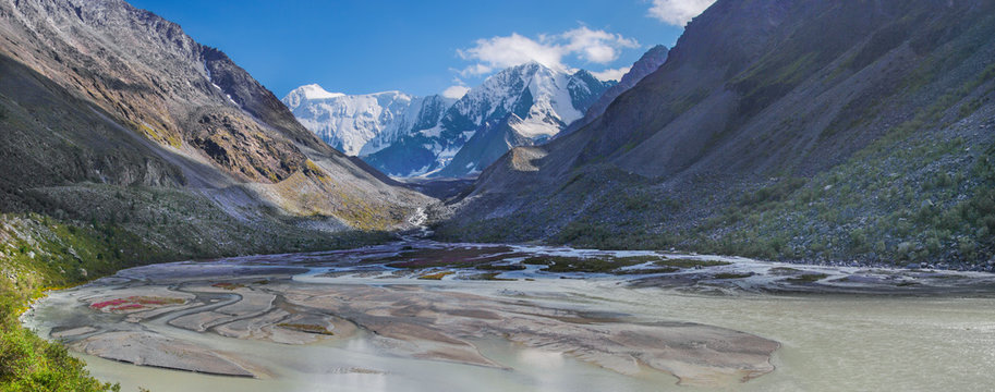 Amazing mountain valley, panoramic image, Altai. Severe gorge, river and snow-capped peaks. Traveling in the mountains, climbing.