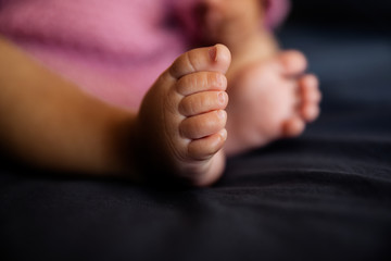 Baby feet on the bed as a background, closeup of infant toes, maternity and babyhood concept