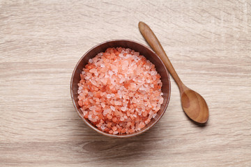 Himalayan pink salt in wooden cup on wooden table