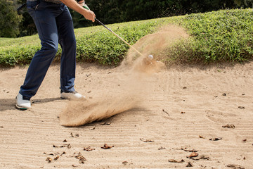 Professional golfer. hits the ball from the sand trap