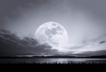 Naklejka na ściany i meble full moon rising over empty reservoir at night . backgrounds night sky with moon and clouds.