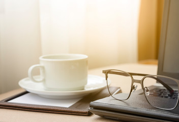 Fototapeta na wymiar Working from home with laptop glasses pen and coffee cup hot in the morning. Workspace background composition with space for text. Enjoy love relax time during working at home with copy space.