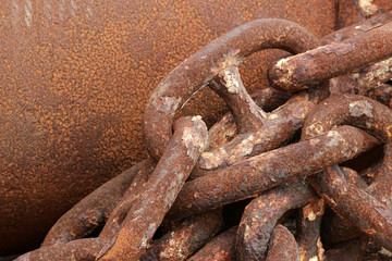 Large rusty and weathered industrial  marine chain links against a blank brown steel background