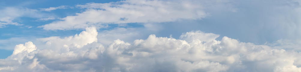 Naklejka na ściany i meble Panorama with a long white cloud on a blue sky