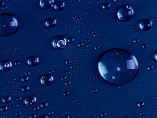drops of blue dark background as a backing. Large drops close up abstract for background