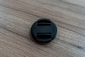 Closeup shot of a lens cover on a wooden background
