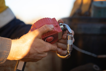 Auditor inspector hand holding inspecting an inertia reel shock absorbing fall arrest fall...