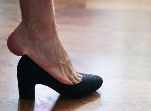 Man's leg trying on a women's shoe - crossdressing, transgender concept