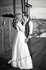 Black and white portrait wedding couple walking on the terrace with lake view