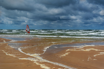Coast of Baltic sea with windsurfing man.