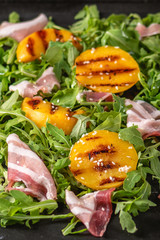 Delicious salad with grilled peaches and prosciutto