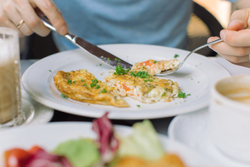 Man eating omelet with bacon and vegetables. Breakfast concept.