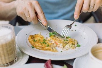 Man eating omelet with bacon and vegetables. Breakfast concept.