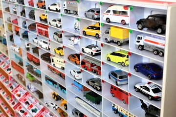 Diecast model cars are displayed for sale on a shelf in a toy store