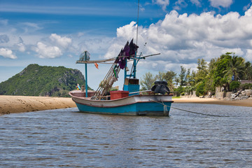 This unique photo shows a fishing boat running aground on the beach in Thailand and the Pak Nam Pran mountain range in the background