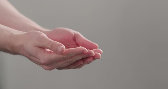 Slow motion man show empty cupped hands on neutral background