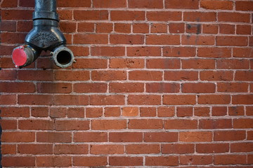 Red brick wall with Fire Department connection.