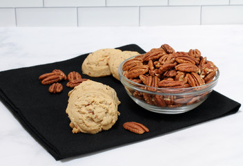 Pecan sandies cookies and a bowl of pecans.