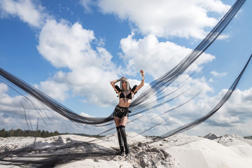 Girl in metal wig and in black retro-futuristic festival outfit. Burning man style photoset in...