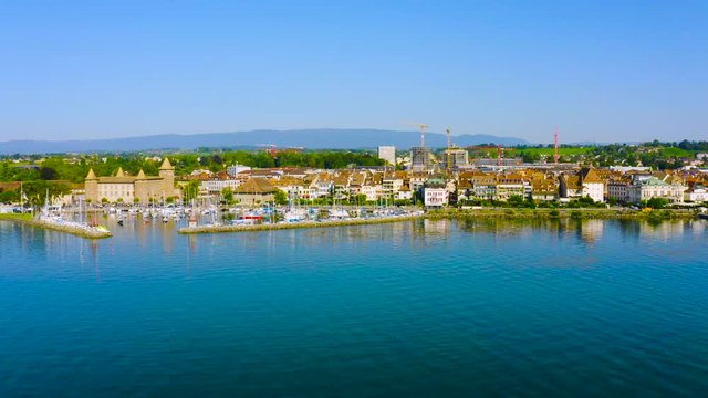 Calm Water Of Lake Leman With Morges Town And Castle On The Background At Daytime In Vaud, Switzerland - aerial drone - low panning shot