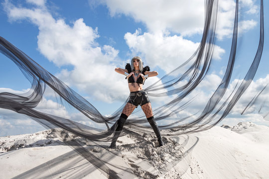 Girl in metal wig and in black retro-futuristic festival outfit. Burning man style photoset in desert.