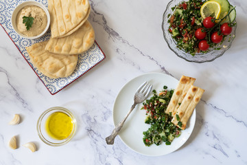 A flat lay food image with a variety of middle eastern arabic inspired dishes.  Set against a plain background with copy space.