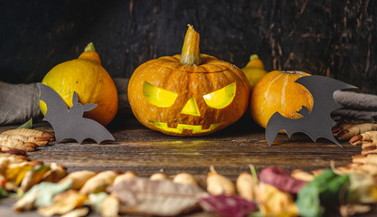 Glowing pumpkin with a carved face and cookies Fingers of a witch. Concept of celebrating Halloween...