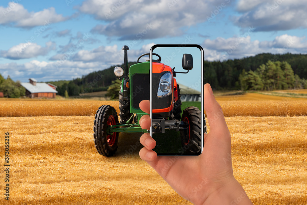 Poster old tractor on the farm. the farmer points his phone at this and a new modern tractor is shown on th
