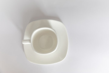 Empty white cup on saucer on white background