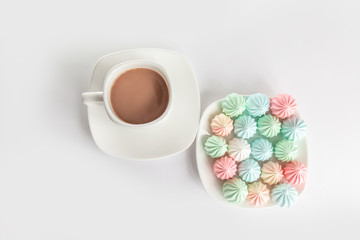 Good morning. meringues and a cup of coffee on a saucer on isolated a white background. Coffee culture concept.