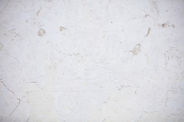 Painted concrete wall with scratches and cracks.