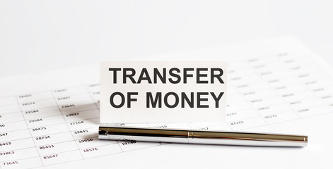 Text TRANSFER OF MONEY on stickers,pen on the background of documents. Financial bookkeeping, Accounting Concept. Top view.
