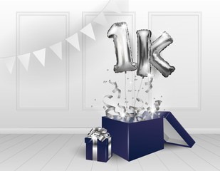 1k one thousand subscribers.Silver balloons. The celebration of the anniversary. Balloons with sparkling confetti fly out of the box, number 1 against the wall. Birthday or wedding decorations.