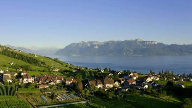 Scenic View Of Savuit Village At Sunset In Lavaux Vineyard, Lake Leman With The Swiss Alps In Background - Aerial shot (pull back)