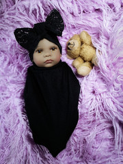 Ethnic reborn baby doll in a  black set with teddy bear