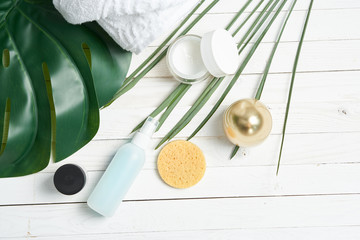 Obraz na płótnie Canvas green leaves cosmetics bathroom supplies decoration decorative wooden background