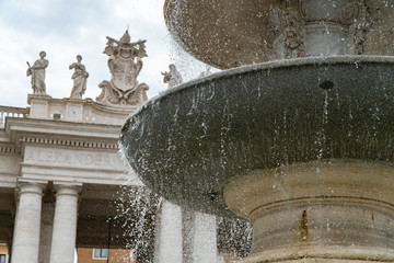Piazza San Pietro in Rome, fountain with the dome and a detail of the church.