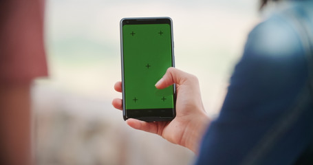 Romantic couple taking a selfie or using green screeen smartphone device in rural town of...