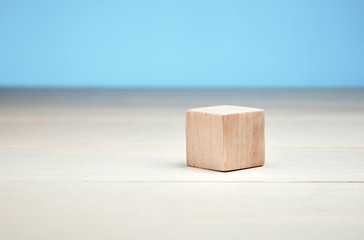 Blank empty wooden block or cube on blue background