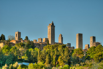 Fototapeta na wymiar San Gimignano en Toscane devant un champ d'olivier en été
