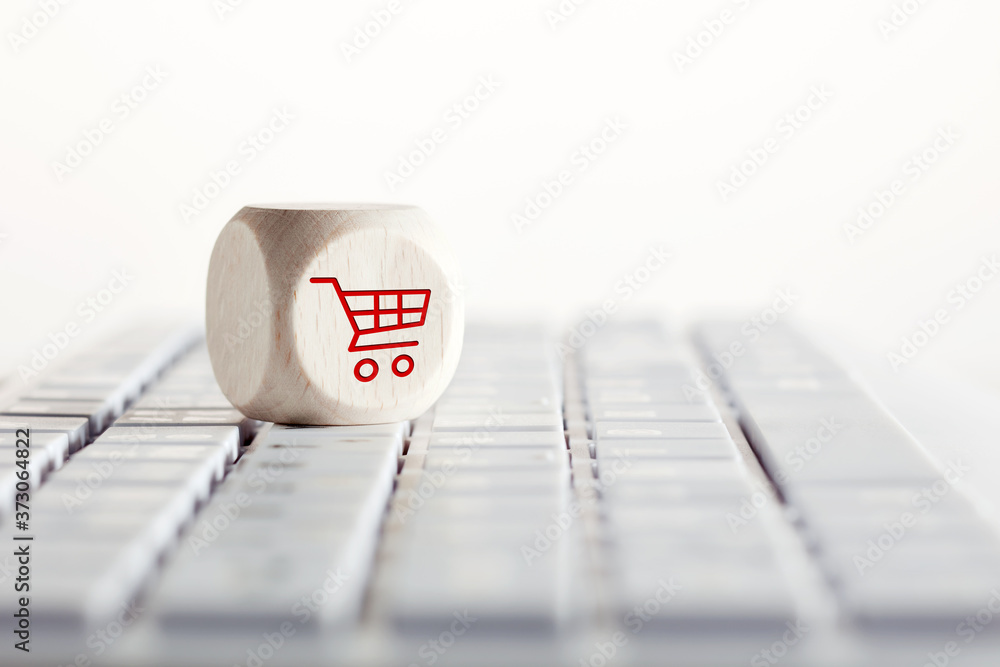 Poster online shopping and e-commerce concept with shopping cart icon on wooden cube on computer keyboard