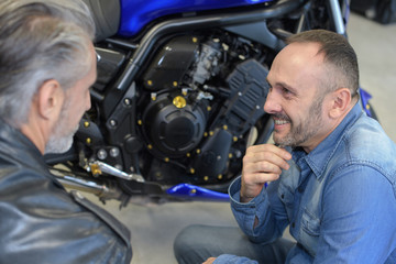 happy male mechanic with his client in garage