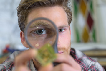 man holding a magnifying glass and magnifying viewer ring